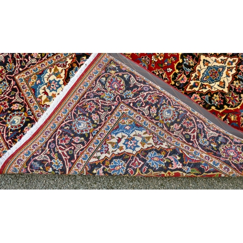 384 - A Kashan rug with floral motifs, on a red ground  83