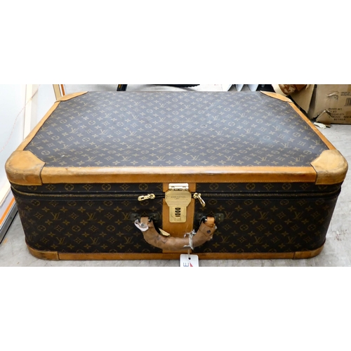 395 - A Louis Vuitton suitcase with a double zipped opening and a combination lock  11