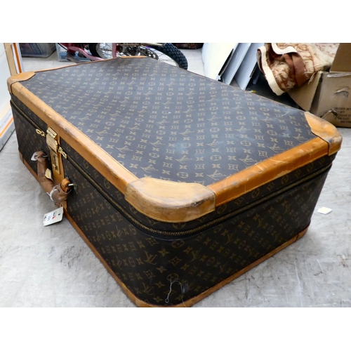 395 - A Louis Vuitton suitcase with a double zipped opening and a combination lock  11