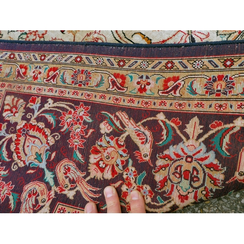 397 - A Persian pure silk rug, decorated with birds, flora and foliate, on a red ground with a black borde... 