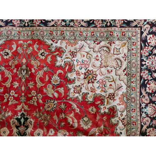 397 - A Persian pure silk rug, decorated with birds, flora and foliate, on a red ground with a black borde... 