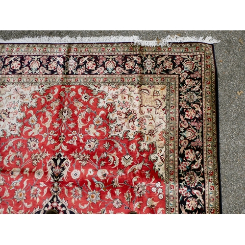 397 - A Persian pure silk rug, decorated with birds, flora and foliate, on a red ground with a black borde... 