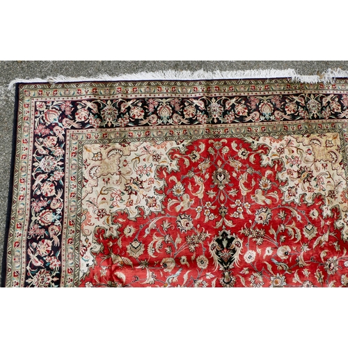 397 - A Persian pure silk rug, decorated with birds, flora and foliate, on a red ground with a black borde... 