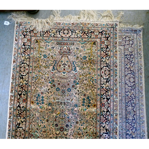 406 - A pair of silk rugs, each decorated with flowers, trees and birds, on a multi-coloured ground  ... 