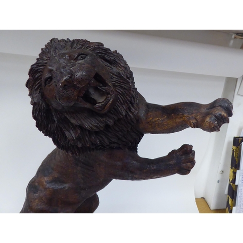 55 - A carved and stained model male lion, in a fighting pose, reared up on his hind legs  23