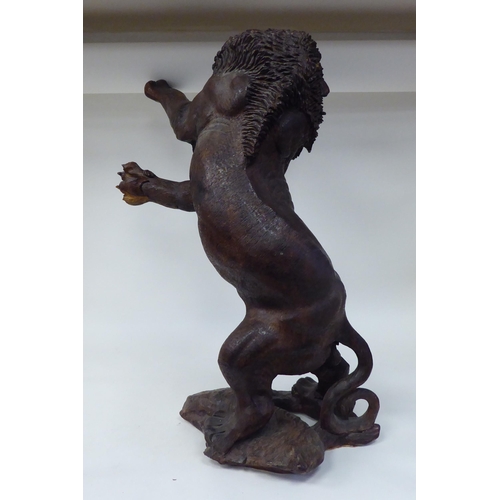 55 - A carved and stained model male lion, in a fighting pose, reared up on his hind legs  23