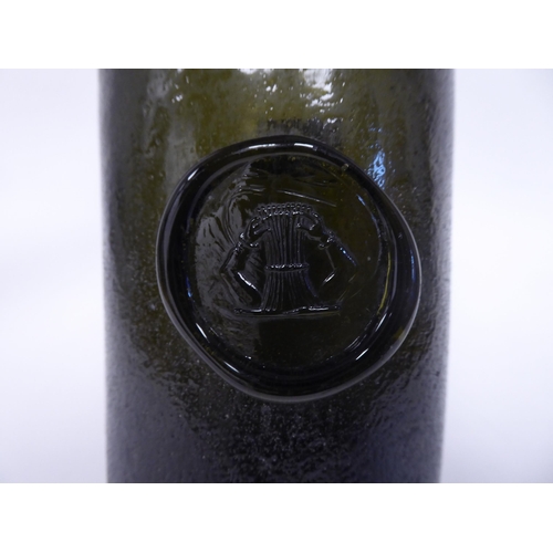 63 - An antique sealed olive green glass wine bottle with a short, shouldered, tapered neck and a kick ba... 