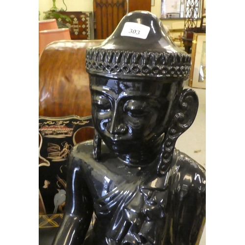 303 - A black painted ceramic model, a seated Buddha  24