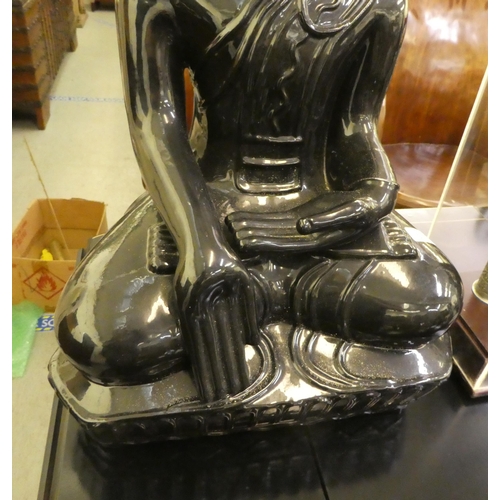 305 - A black painted ceramic model, a seated Buddha  25