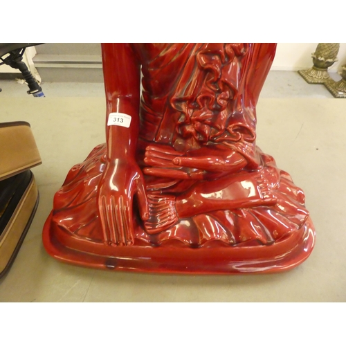 313 - A dark red painted ceramic model, a seated Buddha  24