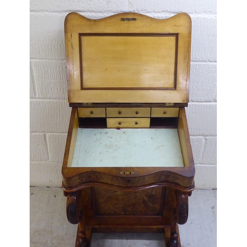 32 - WITHDRAWN A late Victorian walnut Davenport with a hinged lid and scrolled uprights, the side with f... 