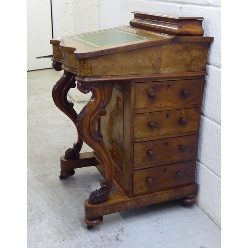 32 - WITHDRAWN A late Victorian walnut Davenport with a hinged lid and scrolled uprights, the side with f... 