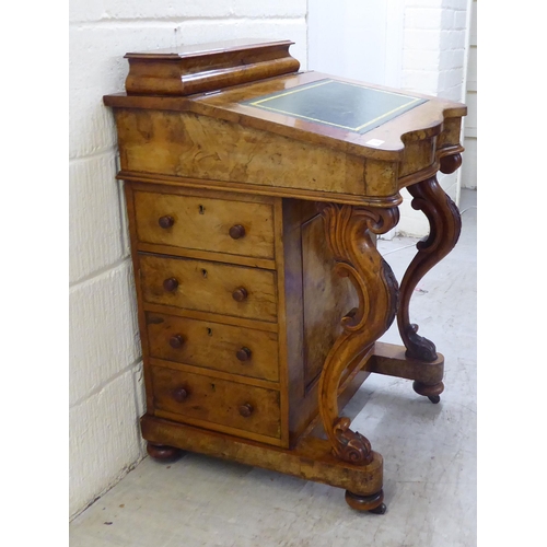 32 - WITHDRAWN A late Victorian walnut Davenport with a hinged lid and scrolled uprights, the side with f... 