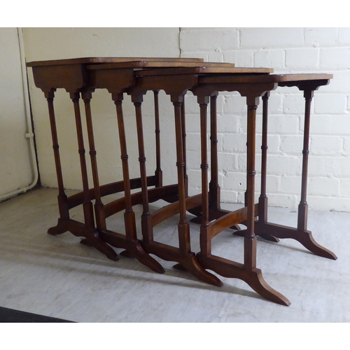 46 - A nesting set of four mid 20thC walnut occasional tables, each raised on slender turned legs and pla... 