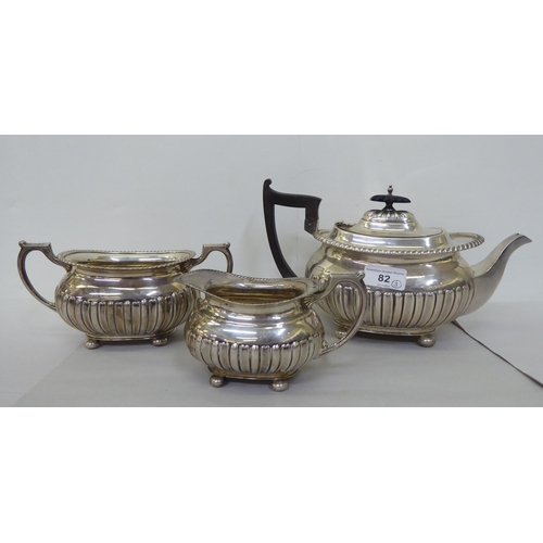 82 - An Edwardian Walker & Hall silver three piece tea set of oval, demi-reeded form  Sheffield 1906 ... 