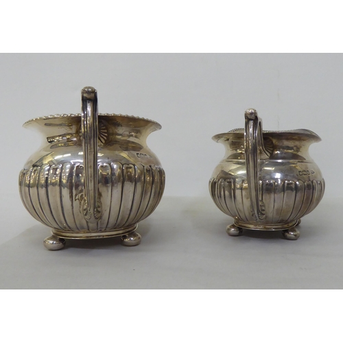 82 - An Edwardian Walker & Hall silver three piece tea set of oval, demi-reeded form  Sheffield 1906 ... 