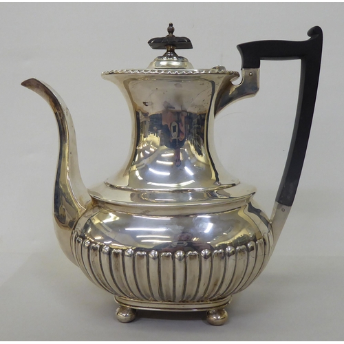 83 - An Edwardian Walker & Hall silver coffee pot of oval, demi-reeded form  Chester 1906  (approx. 2... 