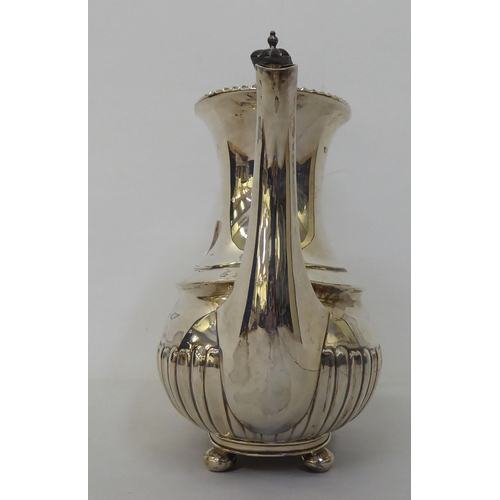 83 - An Edwardian Walker & Hall silver coffee pot of oval, demi-reeded form  Chester 1906  (approx. 2... 