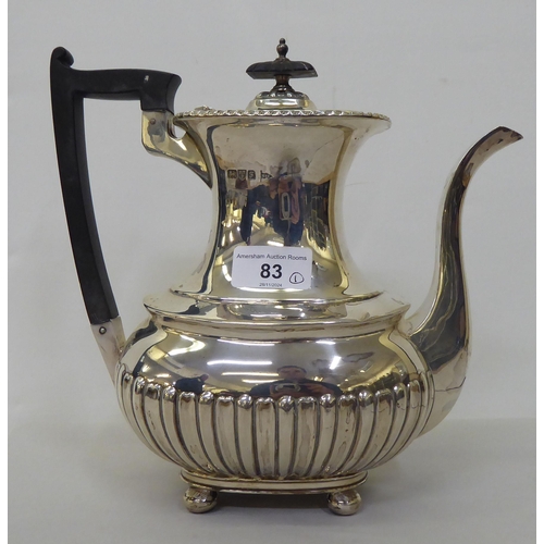 83 - An Edwardian Walker & Hall silver coffee pot of oval, demi-reeded form  Chester 1906  (approx. 2... 