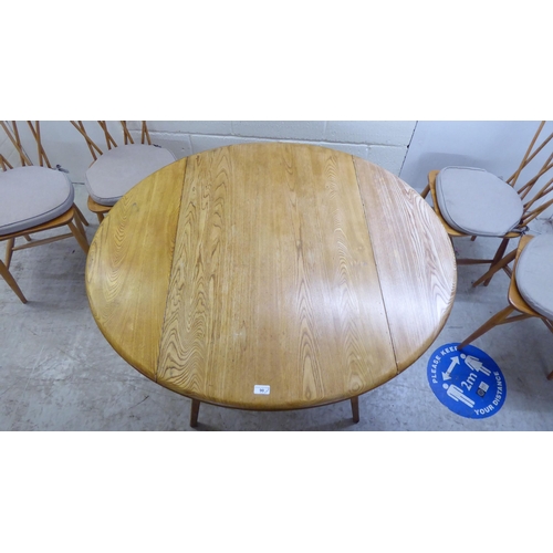 90 - An Ercol light elm drop-leaf dining table, raised on square, tapered legs  30