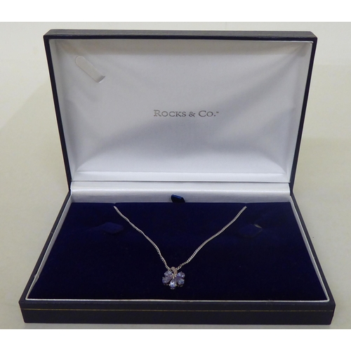 93 - A 9ct white gold pendant necklace, the petal design drop, set with coloured stones