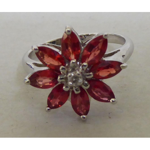 96 - A 9ct white gold, petal design ring, set with red and white stones