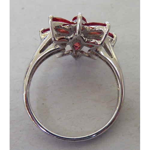 96 - A 9ct white gold, petal design ring, set with red and white stones