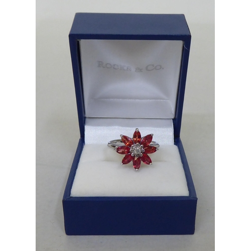 96 - A 9ct white gold, petal design ring, set with red and white stones