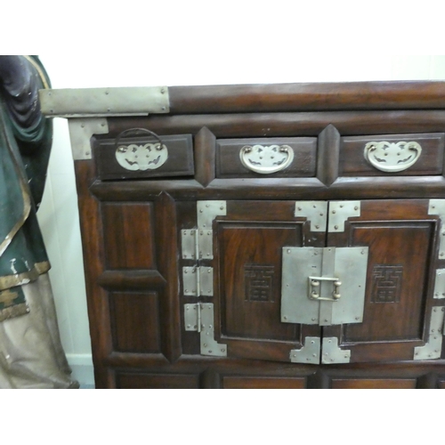 296 - A mid 20thC Chinese elm metal bound cabinet with four short drawers and two doors, raised on bracket... 