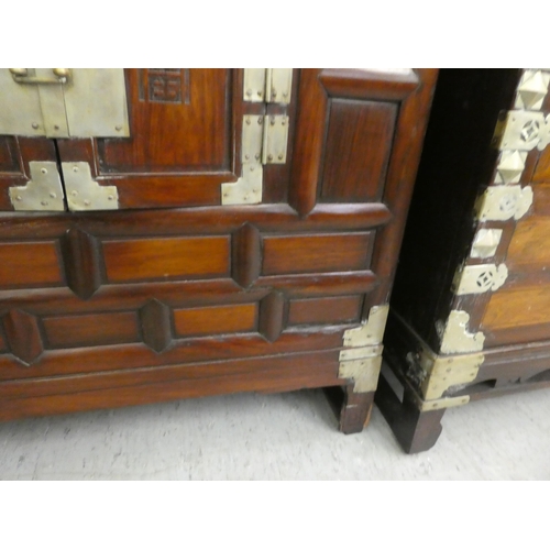 296 - A mid 20thC Chinese elm metal bound cabinet with four short drawers and two doors, raised on bracket... 