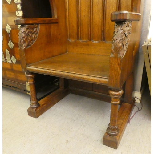 304 - A late Victorian honey coloured oak, Bishop's throne with a high, canopied back with Gothic tracery ... 