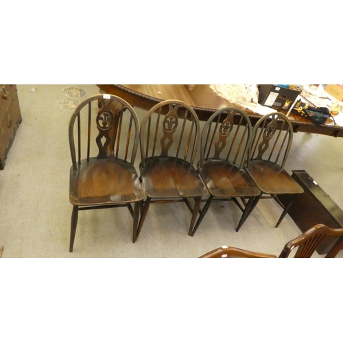 321 - A set of four dark stained Ercol hoop and spindled back chairs, the solid seats raised on turned leg... 