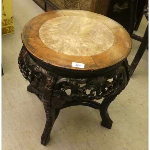 324 - A late 19thC profusely carved teak jardinière stand with an inset marble top, raised on cabri... 