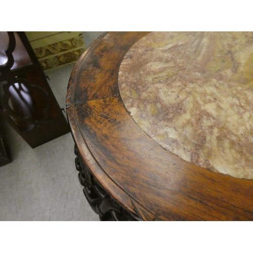 324 - A late 19thC profusely carved teak jardinière stand with an inset marble top, raised on cabri... 