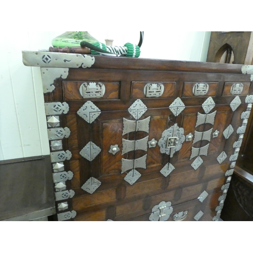 326 - A mid 20thC Chinese elm metal bound cabinet with four short drawers and four doors, raised on bracke... 