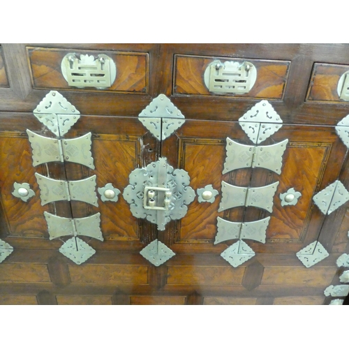 326 - A mid 20thC Chinese elm metal bound cabinet with four short drawers and four doors, raised on bracke... 