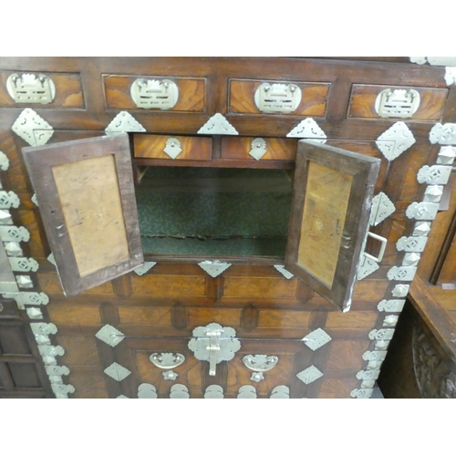 326 - A mid 20thC Chinese elm metal bound cabinet with four short drawers and four doors, raised on bracke... 