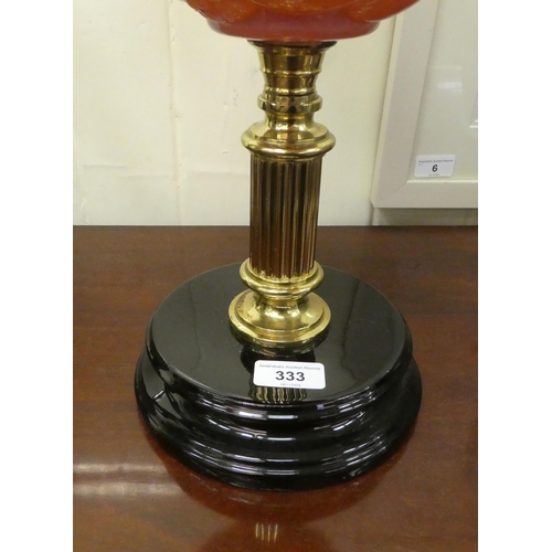 333 - A late Victorian oil lamp with a pink glass reservoir, a brass column and porcelain plinth  16