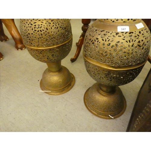 347 - A pair of early 20thC Asian brass lamps of bulbous form with pierced ornament, on a floorstanding ba... 