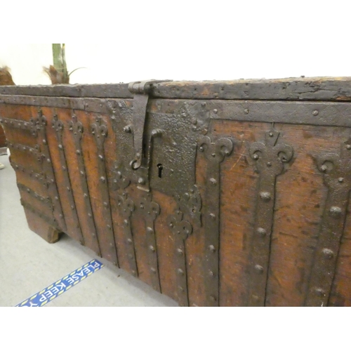 353 - A 17thC low Country oak boarded chest, extensively rivetted iron strapwork, studs and hinges, a clas... 