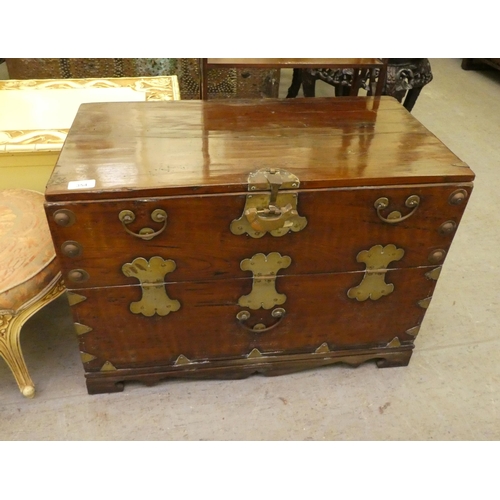 354 - A Chinese elm cabinet with a hinged front, raised on bracket feet  20