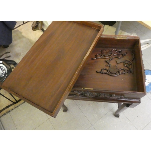 58 - A mid 20thC Chinese rosewood side table, the hinged lid ornately carved with an Oriental landscape a... 