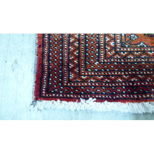 114 - A Persian design rug, decorated with geometric patterns, on a red ground  40