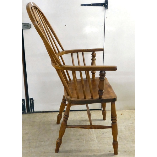 14 - A modern oak framed hoop, spindled and pierced splat back Windsor chair, the solid seat raised on tu... 