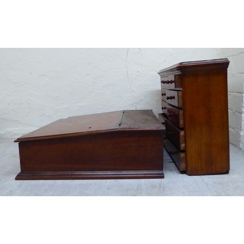 15 - An early/mid 20thC two-part mahogany desk top organiser, the upper section with eleven drawers, over... 