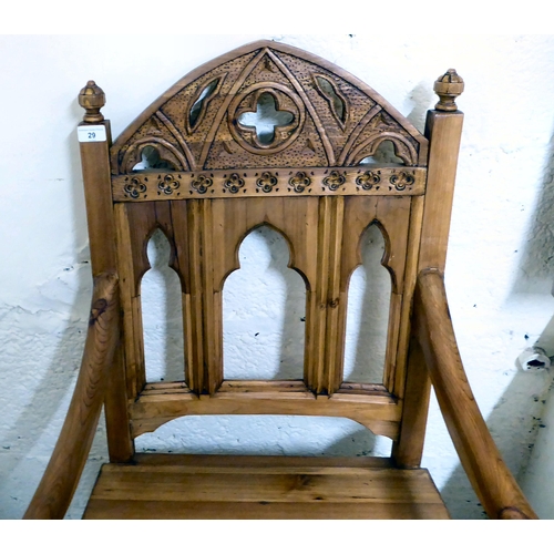 29 - A modern pine and oak framed ecclesiastically themed, open arm hall chair, the solid seat raised on ... 