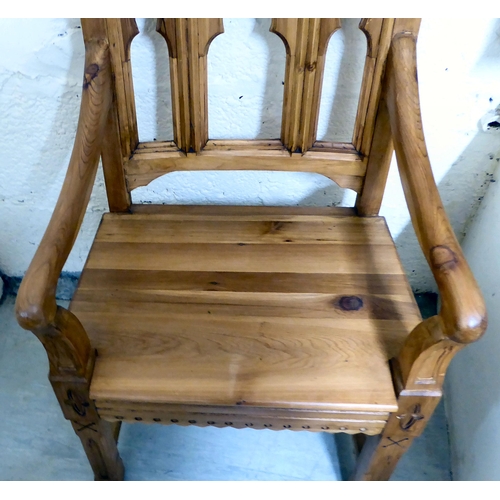 29 - A modern pine and oak framed ecclesiastically themed, open arm hall chair, the solid seat raised on ... 