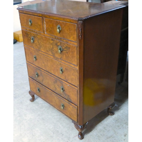 369 - A mid 20thC quarter veneered and walnut finished six drawer dressing chest, raised on stubby, carved... 