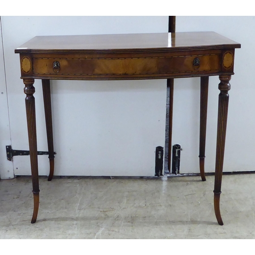 370 - A late 19thC crossbanded mahogany, bow breakfront single drawer side table, raised on tapered, reede... 