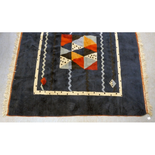 383 - A Caucasian rug, decorated with coloured diamond formation, on a dark blue ground  78